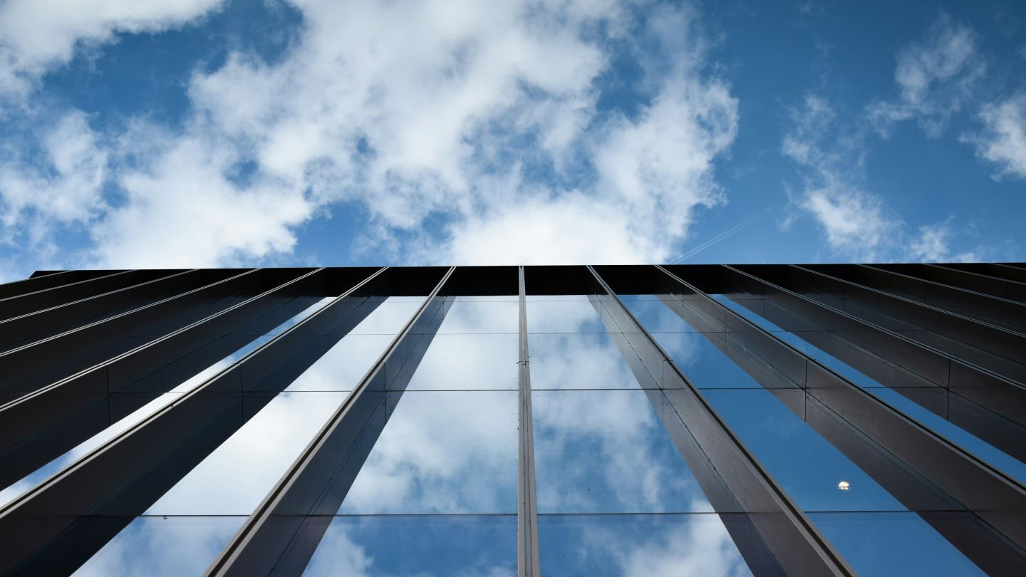 photo of a glass building looking up at the sky