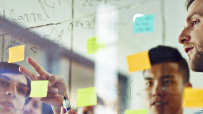 employees at a glass board with notes and post-its 