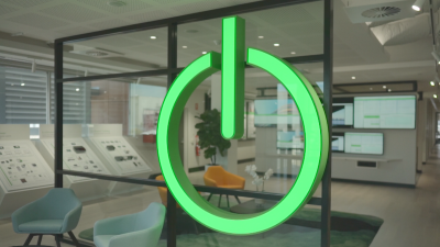 Giant green neon on/off icon on a glass wall in a building