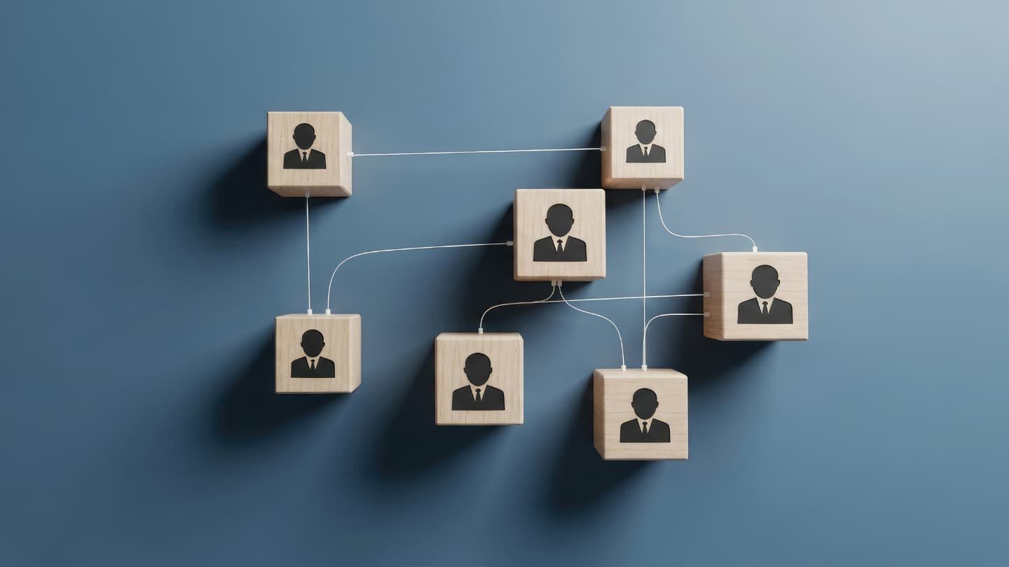 Wooden blocks with business people icons connected by strings represent system thinking in business