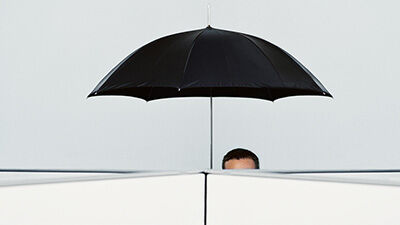 a man standing under a black umbrella