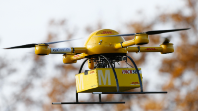 DHL packages being held up in the air by a DHL drone