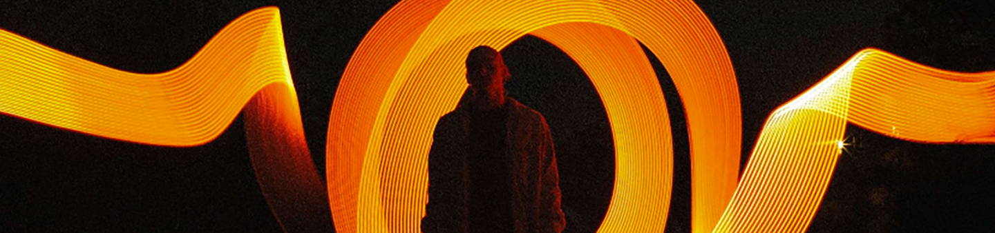person standing in front of glowing orange ribbon