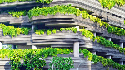 Modern building facade with cascading layers of lush greenery and contemporary architecture.