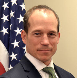 Photo of Jason Pelletier infront of an American Flag Photo of Jason Pelletier infront of an American Flag