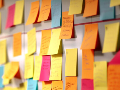 colorful post it notes on a board with things written on them
