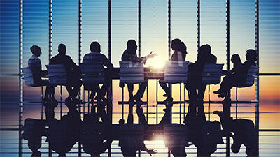 image of figures around an executive conference table