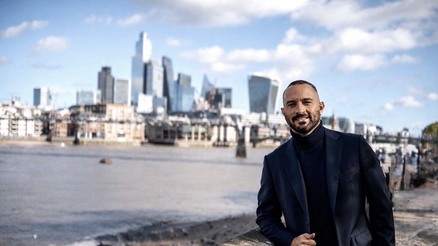 Fabio Caravita standing near the water with a city in the background