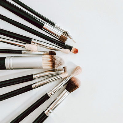 Set of various makeup brushes arranged on a white background.