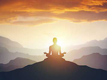 person doing yoga on mountain
