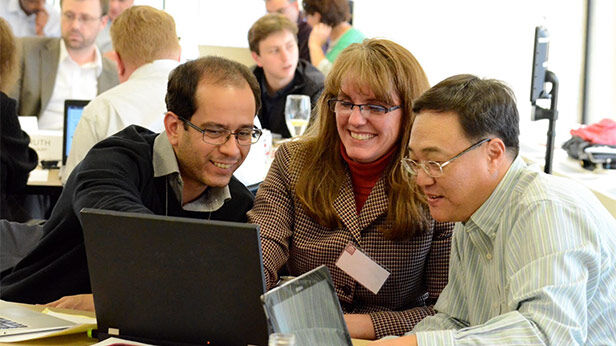 MIT Sloan Executive Education participants engaged in a group workshop in a modern classroom setting.
