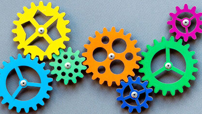 multicolored cogs linked together image number null