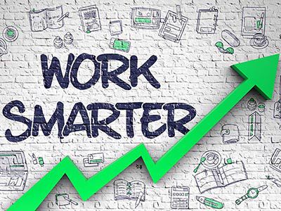 Brick wall that reads ‘Work Smarter’ and that includes illustrations of elements on how to maximize productivity and an arrow trending upward image number null