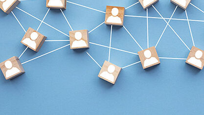Wooden blocks with images of people, connected by a web. image number null