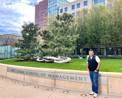 Dipanjan standing in front of MIT Sloan's e62 building
