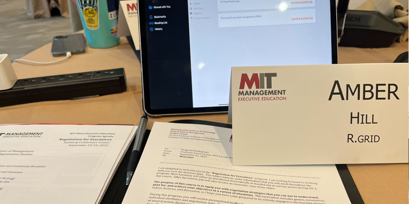 image POV of Dr. Hill at her classroom desk - folder with class materials open, nameplate