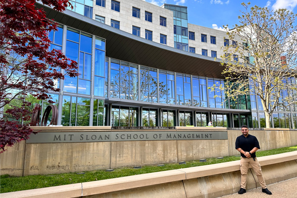 Freddy Leon standing in front of MIT Sloan main building E62