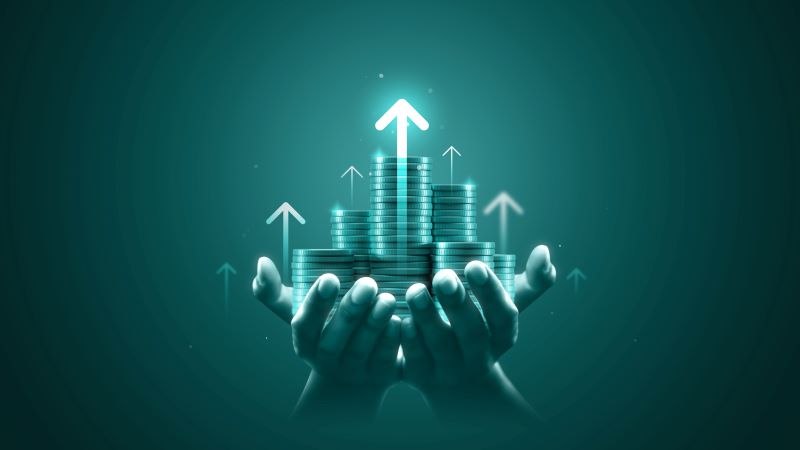 hands holding stacks of coins with arrows pointing up
