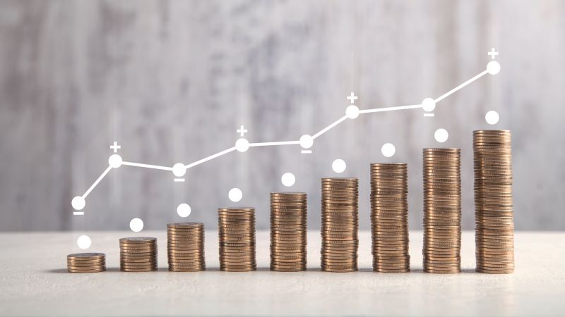 nine stacks of coins getting progressively taller with a line graph above 