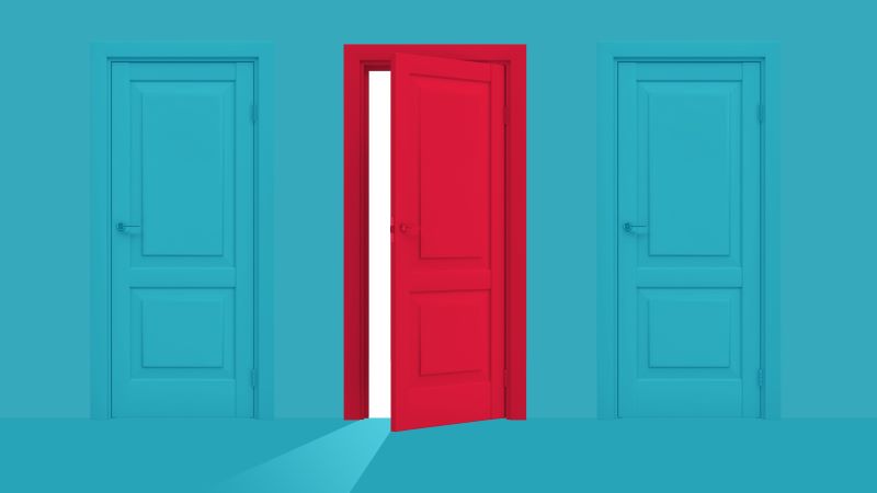 three doors next to each other, two are blue, closed and blending into the background, and one is red and open